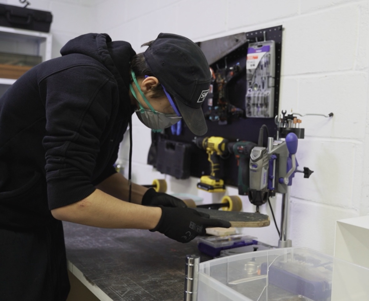 Marcel building an electric skateboard deck in the workshop